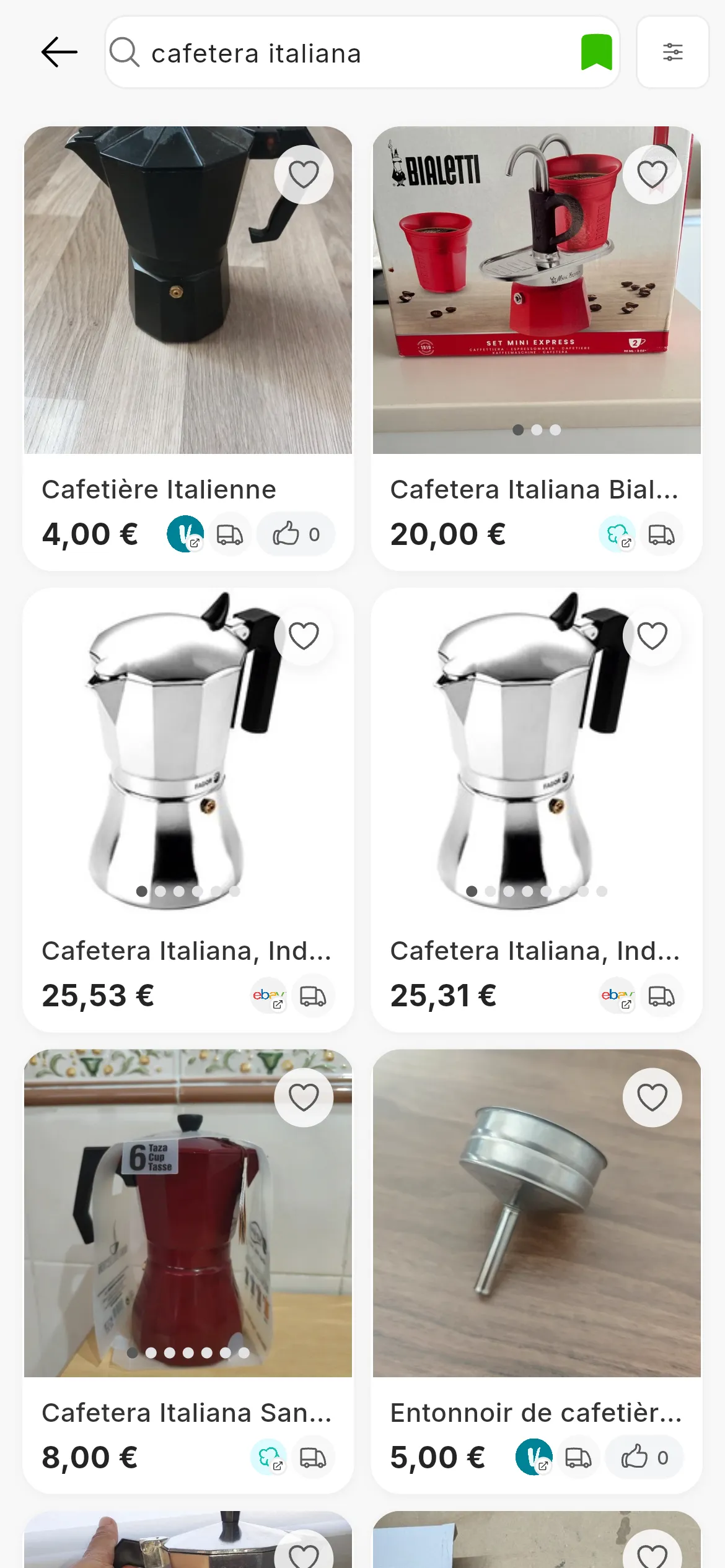 Der Suchbildschirm von RUIT mit der Suche nach cafetera italiana: oben Filter, Sortieren nach, das Suchfeld, Suchen und Suche gespeichert; darunter ein Raster aus Espressokannen von Wallapop, Vinted und eBay, jede mit ihren Fotos, ihrem Titel, ihrem Preis, dem Logo ihres Marktplatzes und dem Herzsymbol