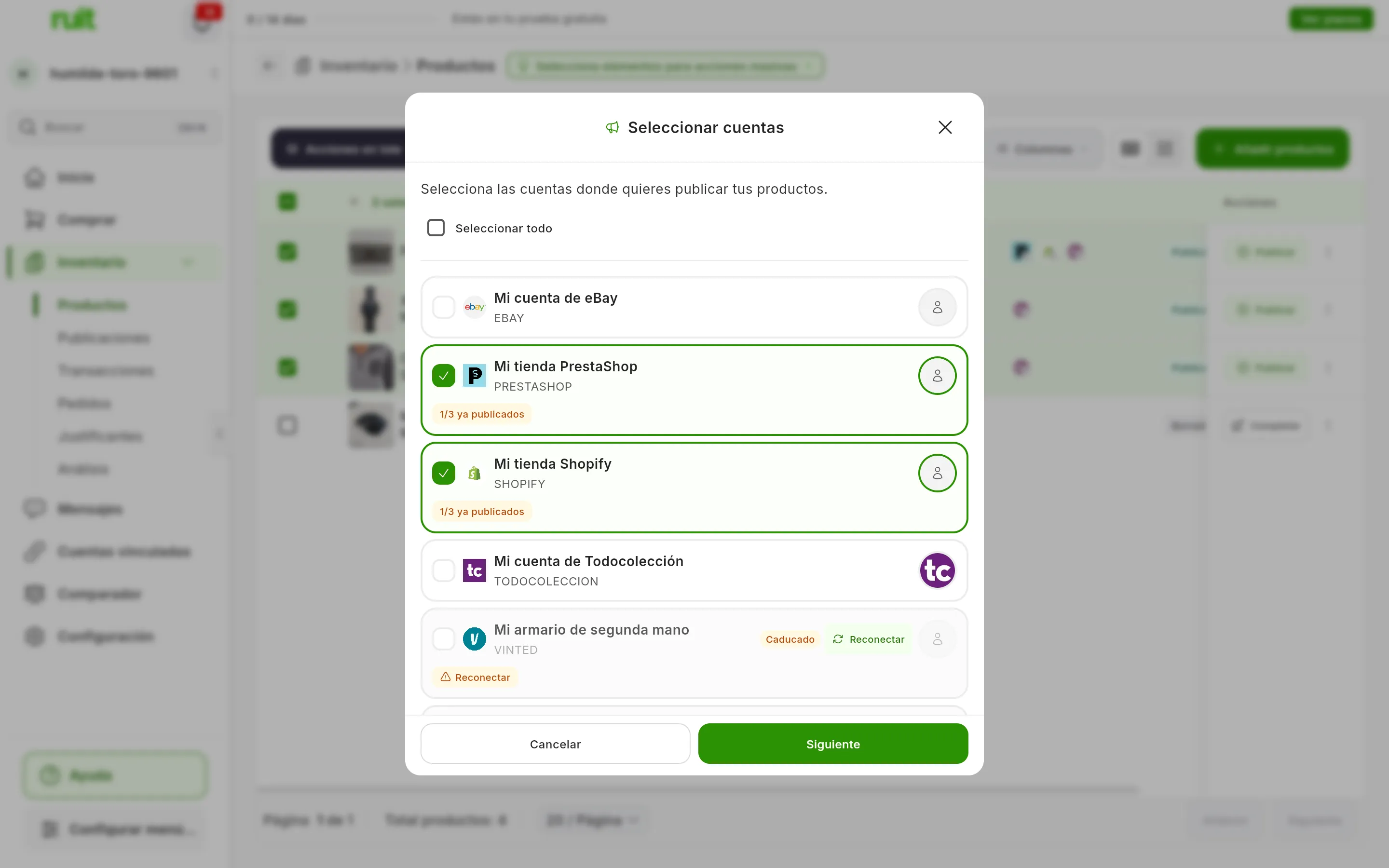 El paso Seleccionar cuentas sobre la tabla difuminada: Mi tienda PrestaShop y Mi tienda Shopify marcadas, cada una con la etiqueta 1/3 ya publicados; Mi cuenta de eBay y Mi cuenta de Todocolección sin marcar, y Mi armario de segunda mano caducado, con Reconectar; abajo, Cancelar y Siguiente