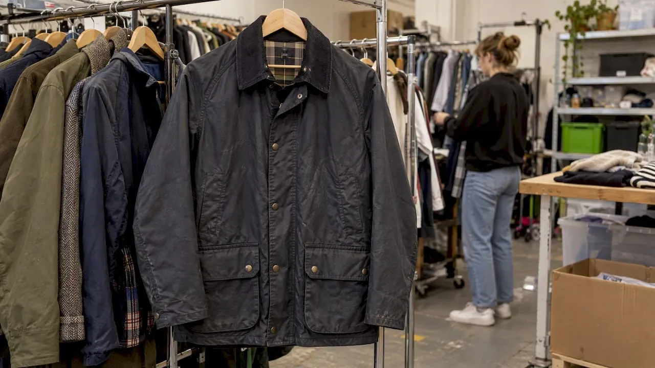 Navy wax jacket hanging on a resale rail